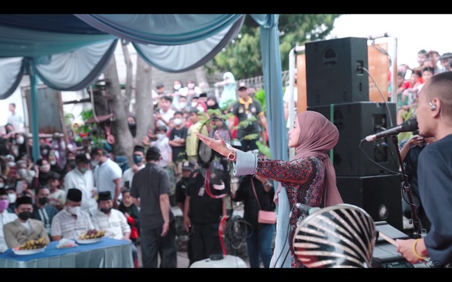 Baru-baru ini, Nissa Sabyan manggung di acara hajatan kampung bersama rekan personelnya Kamal, dan Ayus yang terseret skandal perselingkuhan dengannya. Penyanyi 22 tahun itu diduga menjadi orang ketiga dalam rumah tangga Ayus dan istrinya. Meskipun sempat vakum, SABYAN terlihat manggung di Jaticempaka, Pondok Gede, Bekasi. Foto: dok. YouTube SABYAN