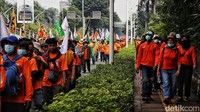 Massa berjalan sembari membawa sejumlah atribut, di antaranya bendera, spanduk, dan poster tuntutan.