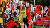 Sejumlah buruh mengibarkan bendera yang dibawanya.