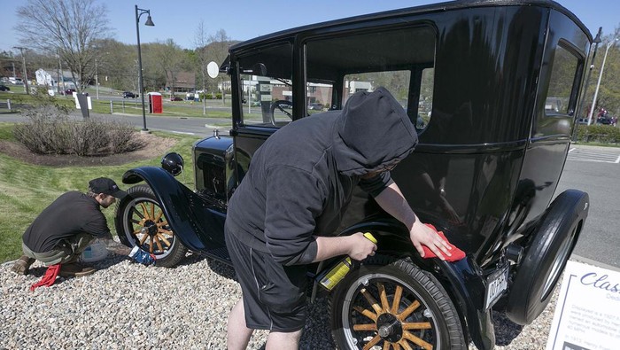 Colin Carabetta, co-owner of Class Act Auto Wash, cleans up a wheel on a 1927 Ford Model T Tudor in front of the business that also features a pet wash at 1275 E. Main St. in Meriden, Conn. Monday, May 9, 2022. The business hosts classic car shows throughout the year. The next car show is scheduled for Saturday, May 21. (Dave Zajac/Record-Journal via AP)