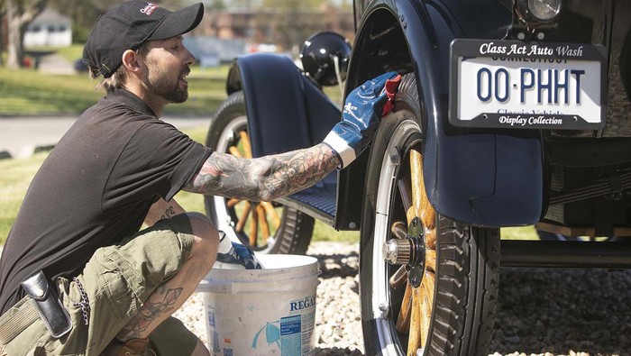 Colin Carabetta, co-owner of Class Act Auto Wash, cleans up a wheel on a 1927 Ford Model T Tudor in front of the business that also features a pet wash at 1275 E. Main St. in Meriden, Conn. Monday, May 9, 2022. The business hosts classic car shows throughout the year. The next car show is scheduled for Saturday, May 21. (Dave Zajac/Record-Journal via AP)
