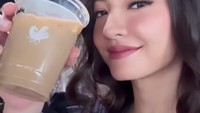 Minum kopi seolah menjadi cara Raline Shah untuk bersantai saat penat melakukan pekerjaannya. Disela-sela waktu kerjanya, Raline Shah asyik menikmati segelas es kopi susu. Foto: Instagram/ralineshah