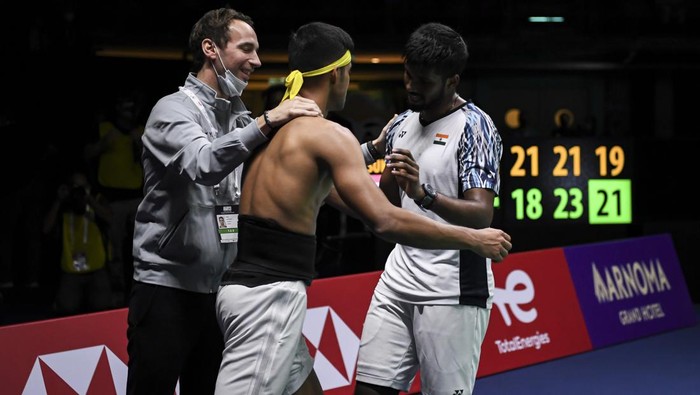Pebulu tangkis ganda putra India Satwiksairaj Rankireddy (kanan) dan Chirag Shetty (tengah) meluapkan kegembiraanya dengan pelatih usai mengalahkan pebulu tangkis ganda putra Indonesia Mohammad Ahsan dan Kevin Sanjaya Sukamuljo dalam pertandingan babak final Piala Thomas 2022 di Impact Arena, Bangkok, Thailand, Minggu (15/5/2022). Rankireddy/Shetty kalahkan Ahsan/Kevin dengan skor 18-21, 23-21 dan 21-19 sehingga India unggul sementara atas Indonesia dengan skor 2-0. ANTARA FOTO/M Risyal Hidayat/YU