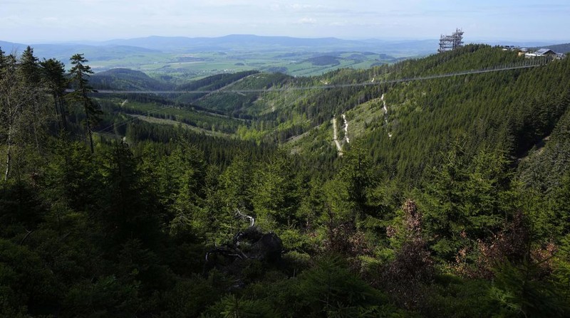 Visitors cross a suspension bridge for the pedestrians that is the longest such construction in the world shortly after its official opening at a mountain resort in Dolni Morava, Czech Republic, Friday, May 13, 2022. The 721-meter (2,365 feet) long bridge is built at the altitude of more than 1,100 meters above the sea level. It connects two ridges of the mountains up to 95 meters above a valley between them. (AP Photo/Petr David Josek)