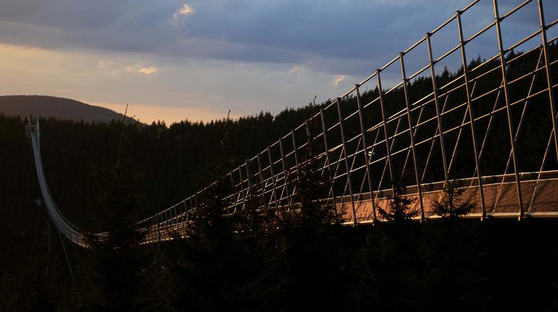 Visitors cross a suspension bridge for the pedestrians that is the longest such construction in the world shortly after its official opening at a mountain resort in Dolni Morava, Czech Republic, Friday, May 13, 2022. The 721-meter (2,365 feet) long bridge is built at the altitude of more than 1,100 meters above the sea level. It connects two ridges of the mountains up to 95 meters above a valley between them. (AP Photo/Petr David Josek)
