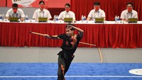 Atlet Wushu Indonesia Seraf Naro Siregar beraksi dengan toya di depan juri.