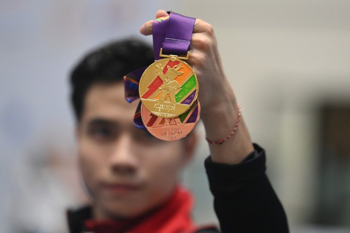 Atlet Wushu Indonesia Seraf Naro Siregar berpose dengan medali yang diraihnya pada Wushu SEA Games 2021 Vietnam di Cau Giay Gymnasium, Hanoi, Vietnam, Minggu (15/5/2021). Seraf Naro Siregar meraih medali emas pada nomor Taolu Daoshu (golok) dan Guns Shu (toya) Putra dan  perunggu pada Taolu Chang Quan Putra. ANTARA FOTO/Zabur Karuru/foc.
