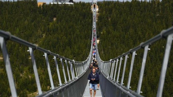 Ada puluhan warga yang datang menikmati suasana di atas jembatan gantung ini.