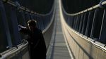 Wisatawan Beraksi di Jembatan Gantung Terpanjang Dunia