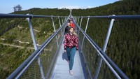 Pengunjung berjalan-jalan melintasi jembatan gantung untuk pejalan kaki yang merupakan konstruksi terpanjang di dunia tak lama setelah pembukaan resminya di sebuah resor pegunungan di Dolni Morava, Republik Ceko, Jumat 13 Mei 2022.