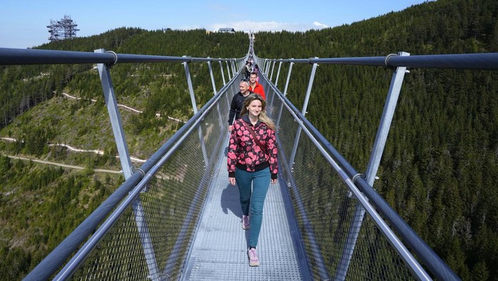 A worker dies some final touches at a suspension bridge for the pedestrians that is the longest such construction in the world a day before its official opening at a mountain resort in Dolni Morava, Czech Republic, Thursday, May 12, 2022. The 721-meter (2,365 feet) long bridge is built at the altitude of more than 1,100 meters above the sea level. It connects two ridges of the mountains up to 95 meters above a valley between them. (AP Photo/Petr David Josek)