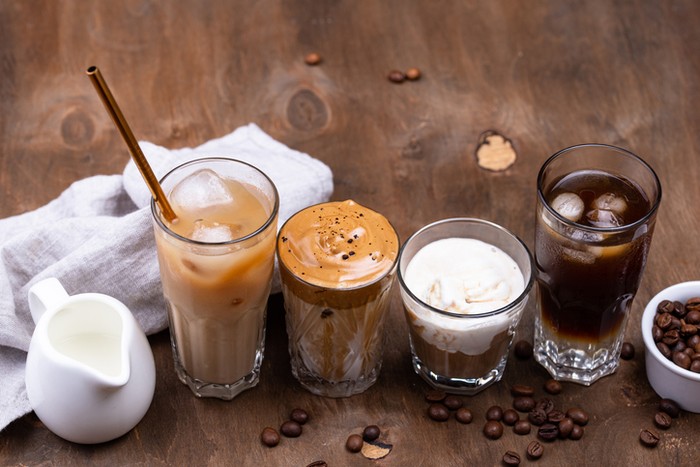 Cold brew coffee with ice cream in glasses on wooden rustic table, delicious summer dessert