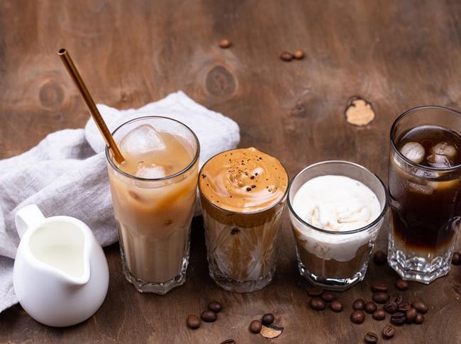 Cold brew coffee with ice cream in glasses on wooden rustic table, delicious summer dessert