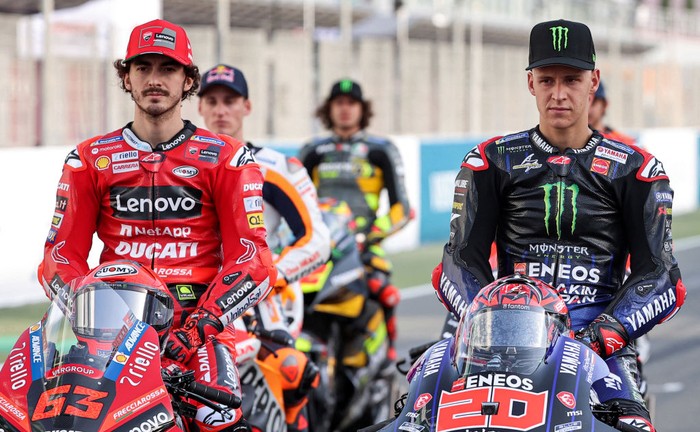 Ducati Lenovo Teams Italian rider Francesco Bagnaia (L) and Monster Energy Yamaha MotoGPs French rider Fabio Quartararo pose in a group photo with other riders ahead of the Qatar MotoGP Grand Prix at the Losail International Circuit on the outskirts of Qatars capital Doha on March 3, 2022. (Photo by KARIM JAAFAR / AFP) (Photo by KARIM JAAFAR/AFP via Getty Images)