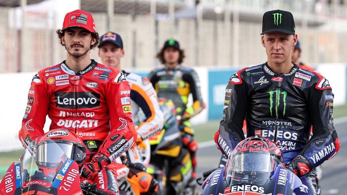 Ducati Lenovo Teams Italian rider Francesco Bagnaia (L) and Monster Energy Yamaha MotoGPs French rider Fabio Quartararo pose in a group photo with other riders ahead of the Qatar MotoGP Grand Prix at the Losail International Circuit on the outskirts of Qatars capital Doha on March 3, 2022. (Photo by KARIM JAAFAR / AFP) (Photo by KARIM JAAFAR/AFP via Getty Images)