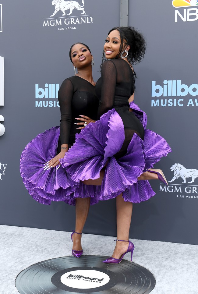 Duo hip-hop JT dan Yung dari Miami of City Girls bergaya kembar ala balerina dengan dress bergaya tutu. Namun, rok ungu dengan lipitan besar yang dramatis tampak seperti sisa serutan pensil. (Foto: WireImage/Bryan Steffy)
