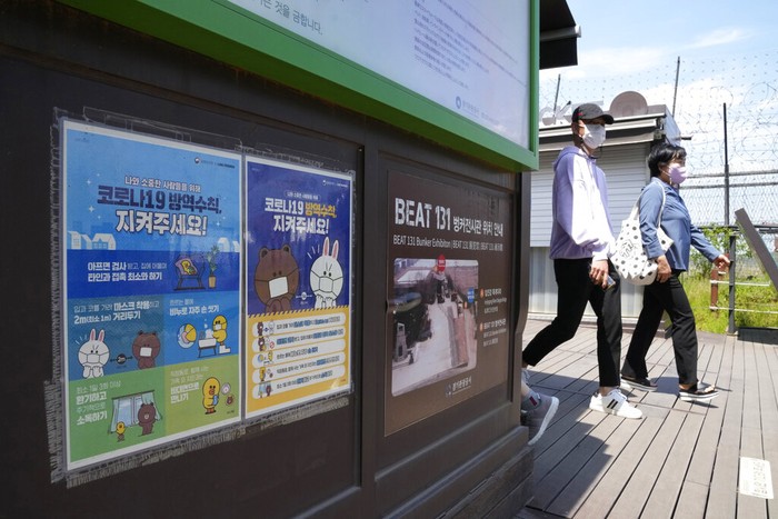 People pass by posters reminding precautions against the coronavirus at the Imjingak Pavilion in Paju, South Korea, near the border with North Korea, Sunday, May 15, 2022. North Korea has confirmed 15 more deaths and hundreds of thousands of additional patients with fevers as it mobilizes more than a million health and other workers to try to suppress the countrys first COVID-19 outbreak, state media reported Sunday. The signs read The precautions against the coronavirus 19. (AP Photo/Ahn Young-joon)