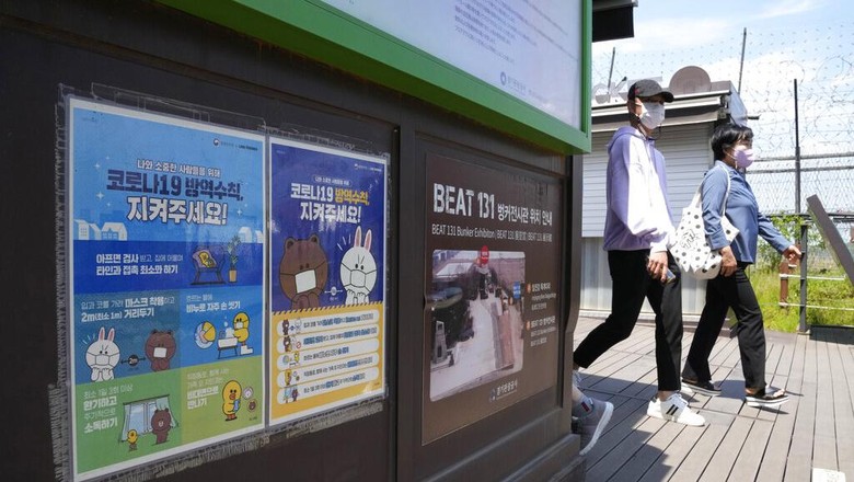 Kim Jong Un Bermasker Tinjau Apotek Saat COVID Merebak di Korut People pass by posters reminding precautions against the coronavirus at the Imjingak Pavilion in Paju, South Korea, near the border with North Korea, Sunday, May 15, 2022. North Korea has confirmed 15 more deaths and hundreds of thousands of additional patients with fevers as it mobilizes more than a million health and other workers to try to suppress the countrys first COVID-19 outbreak, state media reported Sunday. The signs read The precautions against the coronavirus 19. (AP Photo/Ahn Young-joon)