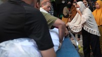 Warga mengangkat jenazah korban kecelakaan bus pariwisata untuk disalatkan.
