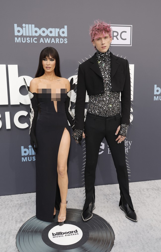 Penampilan Megan Fox di Billboard Music Awards 2022 matching dengan tunangannya Machine Gun Kelly yang mengenakan setelan busana serba hitam dari Dolce & Gabbana. Ia memadukan cropped blazer dan celana panjang beraksen duru-duri dengan turtleneck berhias bebatuan. Sementara sepatu boots hitam dihiasi studs pada pinggirannya. Foto: Getty Images/Frazer Harrison