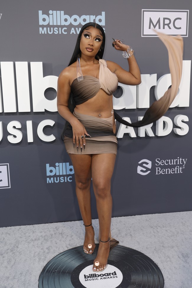 Tren bandage dress kembali dibawakan rapper Megan Thee Stallion, tapi dengan twist yang seksi. Sayangnya, dekorasi berupa kain tambahan di bagian belakang bikin gayanya effortless alias terlalu memaksa. (Foto: Getty Images/Frazer Harrison)