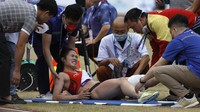 Dinh Thi Bich yang cedera jelang finis mendapat perawatan medis.