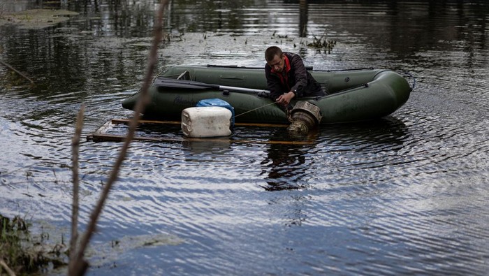 Penampakan Banjir di Ukraina yang Berhasil Menghalau Pasukan Rusia Masuk Kiev Local residents walks along a flooded area after Ukrainian military forces opened a dam to flood an residencial area in order to stop advance of Russian forces to arrive to the capital city of Kyiv, in Demydiv, Ukraine, May, 15, 2022. REUTERS/Carlos Barria TPX IMAGES OF THE DAY