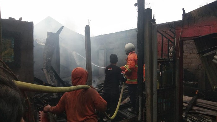 Petugas saat melakukan pemadaman api di rumah Ketut Suarnika di Banjar Dinas Kaje, Desa Busungbiu, Kecamatan Busungbiu, Kabupaten Buleleng