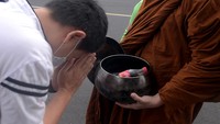 Umat Buddha memberikan derma kepada biksu saat prosesi pindapatta sebagai rangkaian perayaan Tri Suci Waisak 2566 BE/2022 di Manado, Sulawesi Utara. ANTARA FOTO/Adwit B Pramono.