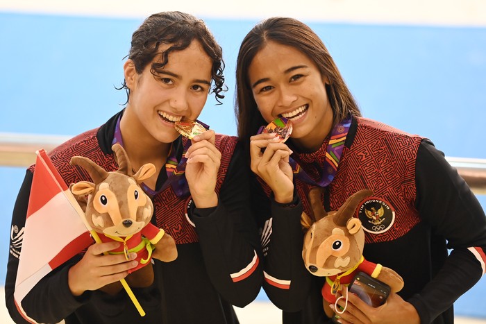 Perenang Indonesia Masriani Wolf (kiri) dan Anak Agung Istri Ratih Atmaja menggigit medali mereka usai pengalungan medali nomor 50 meter gaya punggung putri renang SEA Games 2021 Vietnam di Aquatic Sport Palace, Hanoi, Vietnam, Minggu (15/5/2022). Masriani meraih medali emas setelah menduduki finis pertama dengan catatan waktu 29,21 detik, sementara rekannya Anak Agung Istri Ratih Atmaja meraih medali perunggu setelah finis ketiga dengan catatan waktu 29,59 detik.
 ANTARA FOTO/Aditya Pradana Putra/YU