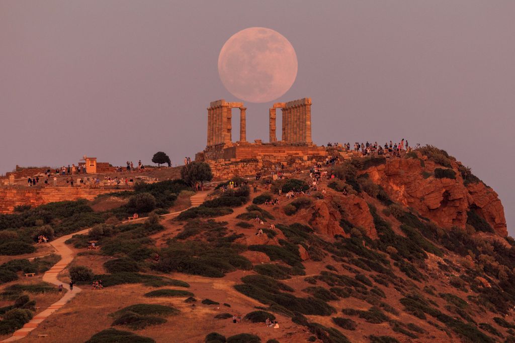 Super 'Flower' Moon dengan indah muncul di belakang kuil kuno Poseidon, Yunani pada Minggu (15/5). (REUTERS/ALKIS KONSTANTINIDIS)