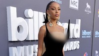 Tak hanya menghiasi telinganya, aksesori emas tersebut juga dipasang Doja Cat di bagian dada. (Foto: Getty Images via AFP/AMY SUSSMAN) 