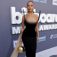 Doja Cat juga mengatakan bahwa penampilannya di Billboard Music Awards 2022 ini menggambarkan ‘anatomi dan ruang angkasa.’ Ruang angkasa ditampilkannya melalui gaya busananya yang menghadirkan gaun bergaya futuristik dan tas bentuk planet Saturnus berwarna emas. Foto: Getty Images via AFP/AMY SUSSMAN