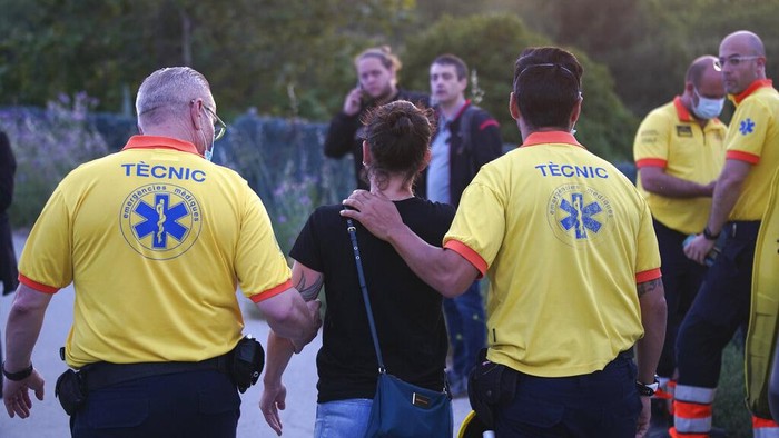 A passenger is helped by medics after a train crash in Sant Boi near Barcelona, Spain, Monday, May 16, 2022. A goods train smashed into a rush-hour passenger train in Catalonia, killing an engineer and injuring 85 people as it came into the Sant Boi station near Barcelona, crashing into the front of the passenger train that was pulling out of the station. Catalan emergency services said crews were helping to evacuate the about 100 people on board the passenger train. (AP Photo/Joan Mateu Para)