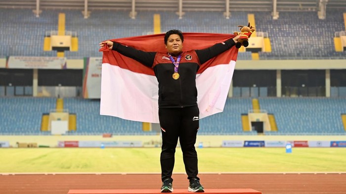 Eki Febri Sumbang Medali Emas SEA Games untuk Indonesia Atlet Indonesia Eki Febri Ekawati membentangkan bendera Merah Putih usai pengalungan medali nomor tolak peluru putri SEA Games 2021 Vietnam di Stadion Nasional My Dinh, Hanoi, Vietnam, Selasa (17/5/2022). Eki Febri meraih medali emas setelah melakukan tolakan terbaik sejauh 15,2 meter. ANTARA FOTO/Aditya Pradana Putra/rwa.