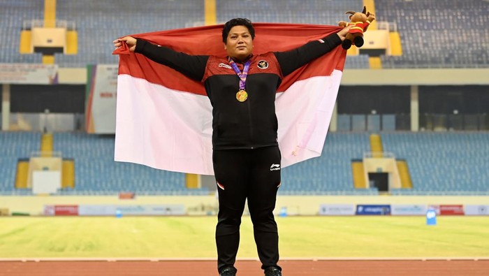 Atlet Indonesia Eki Febri Ekawati membentangkan bendera Merah Putih usai pengalungan medali nomor tolak peluru putri SEA Games 2021 Vietnam di Stadion Nasional My Dinh, Hanoi, Vietnam, Selasa (17/5/2022). Eki Febri meraih medali emas setelah melakukan tolakan terbaik sejauh 15,2 meter. ANTARA FOTO/Aditya Pradana Putra/rwa.