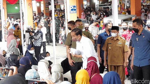 Jokowi memberi bantuan berupa tongkat ke pedagang kelontong bernama Agus Katamso (54) yang merupakan penyandang disabilitas (M Sholihin/detikcom)