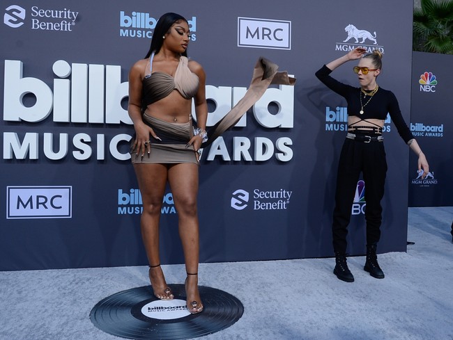 Kehadirannya menjadi atensi juru foto karena Megan Thee Stallion mengenakan busana yang mengekspos perutnya dan kakinya serta hadir dengan detail cut out di bagian pinggang. Top model Cara Delevingne.juga ikut penasaran dengan gaya Megan. Foto: Photo by Mindy Small/FilmMagic