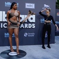 Kehadirannya menjadi atensi juru foto karena Megan Thee Stallion mengenakan busana yang mengekspos perutnya dan kakinya serta hadir dengan detail cut out di bagian pinggang. Top model Cara Delevingne.juga ikut penasaran dengan gaya Megan. Foto: Photo by Mindy Small/FilmMagic