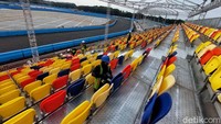Tampak pekerja tengah memasang kursi di tribun penonton.