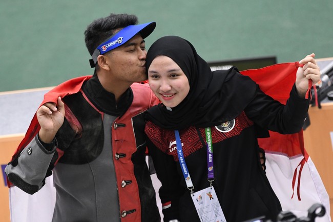 Petembak Fathur Gustafian (kiri) mencium kekasihnya yang juga petembak peraih medali emas, Dewi Laila Mubarokah (kanan), usai memenangkan nomor 10 meter air rifle (senapan angin) putra menembak SEA Games 2021 Vietnam di Hanoi Sports Training and Competition Center, Hanoi, Vietnam, Selasa (17/5/2022). Fathur meraih medali emas setelah meraih poin terbanyak 247,4 poin. ANTARA FOTO/Aditya Pradana Putra/YU
