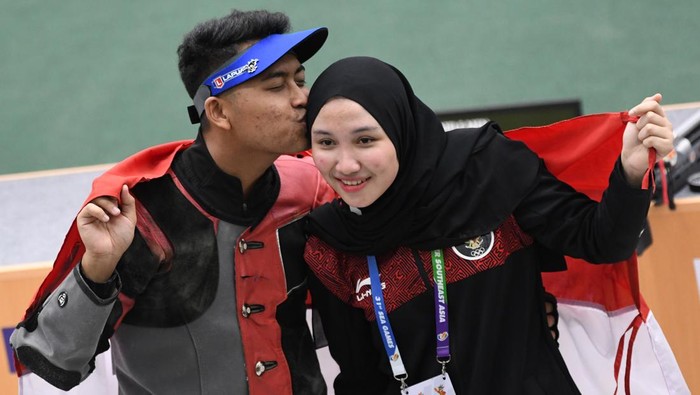 Petembak Fathur Gustafian (kiri) mencium kekasihnya yang juga petembak peraih medali emas, Dewi Laila Mubarokah (kanan), usai memenangkan nomor 10 meter air rifle (senapan angin) putra menembak SEA Games 2021 Vietnam di Hanoi Sports Training and Competition Center, Hanoi, Vietnam, Selasa (17/5/2022). Fathur meraih medali emas setelah meraih poin terbanyak 247,4 poin. ANTARA FOTO/Aditya Pradana Putra/YU