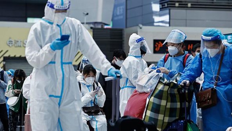 SHANGHAI, CHINA - MAY 17: Passengers in protective suits wait for their trains at Hongqiao Railway Station on May 17, 2022 in Shanghai, China. Shanghai has basically cut off community transmission of COVID-19 in 16 districts and launched a three-phase plan to restore production and life to normal. (Photo by Yin Liqin/China News Service via Getty Images)