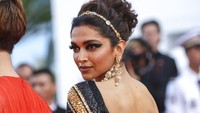 Dengan riasan yang membuat warna kulitnya terlihat natural, Deepika Padukone menyempurnakan penampilannya dengan aksesori anting panjang dan hiasan kepala senada. (Foto: Vianney Le Caer/Invision/AP/Vianney Le Caer)