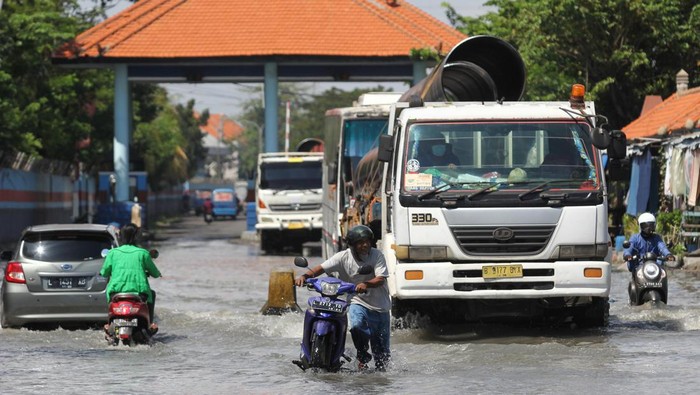 Pelabuhan Kalimas Terendam Banjir Rob Pekerja berjalan melintasi genangan banjir rob di Pelabuhan Kalimas, Surabaya, Jawa Timur, Rabu (18/5/2022). Sebagian dermaga di Pelabuhan Kalimas tergenang banjir rob akibat pasang air laut yang tinggi, namun aktivitas bongkar muat di pelabuhan tersebut masih berjalan normal. ANTARA FOTO/Didik Suhartono/wsj.