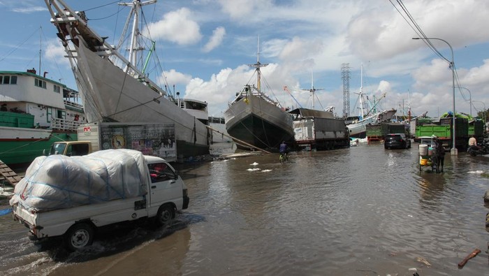 Pelabuhan Kalimas Terendam Banjir Rob Pekerja berjalan melintasi genangan banjir rob di Pelabuhan Kalimas, Surabaya, Jawa Timur, Rabu (18/5/2022). Sebagian dermaga di Pelabuhan Kalimas tergenang banjir rob akibat pasang air laut yang tinggi, namun aktivitas bongkar muat di pelabuhan tersebut masih berjalan normal. ANTARA FOTO/Didik Suhartono/wsj.