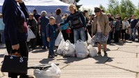 Pengungsi dari Ukraina timur mengantre untuk menerima tas berisi bahan makanan yang disumbangkan.