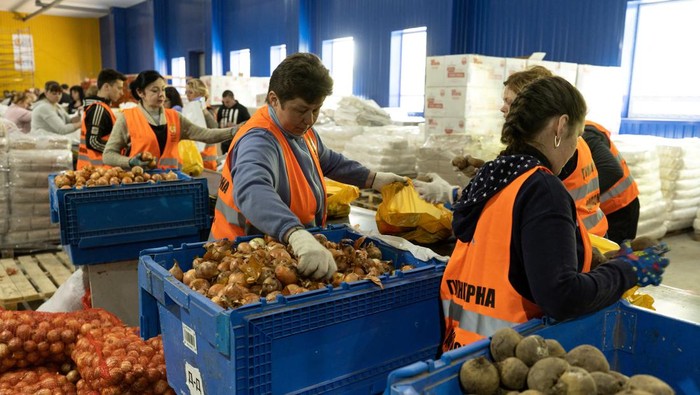 Potret Distribusi Ribuan Bantuan Makanan untuk Pengungsi di Dnipro, Ukraina Displaced people from eastern Ukraine wait in line to receive bags with groceries donated by World Central Kitchen, amid Russia's invasion of Ukraine, in Mahdalynivka outside Dnipro, Ukraine May 13, 2022. Picture taken May 13, 2022. REUTERS/Jorge Silva