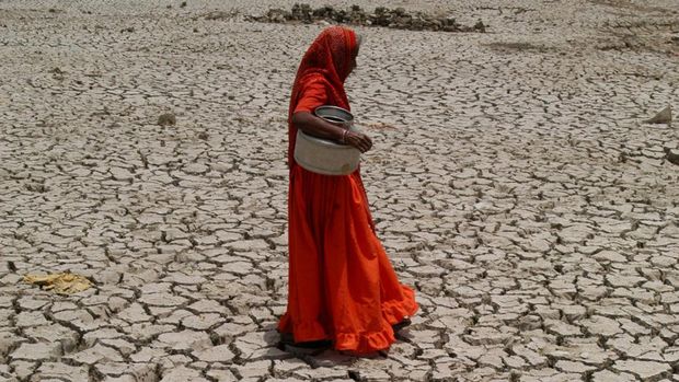 Seorang wanita berjalan dilahan yang kering di India. (Universal Images Group via Getty Images)