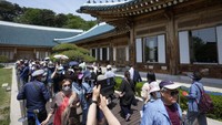 Dahulu, kompleks ini terkesan ketat, namun sekarang seperti pekan raya. Ada kerumunan orang yang datang melihat sekeliling bangunan dan ada pula yang berdiri dalam antrean yang panjang. (AP/Ahn Young-Joon)